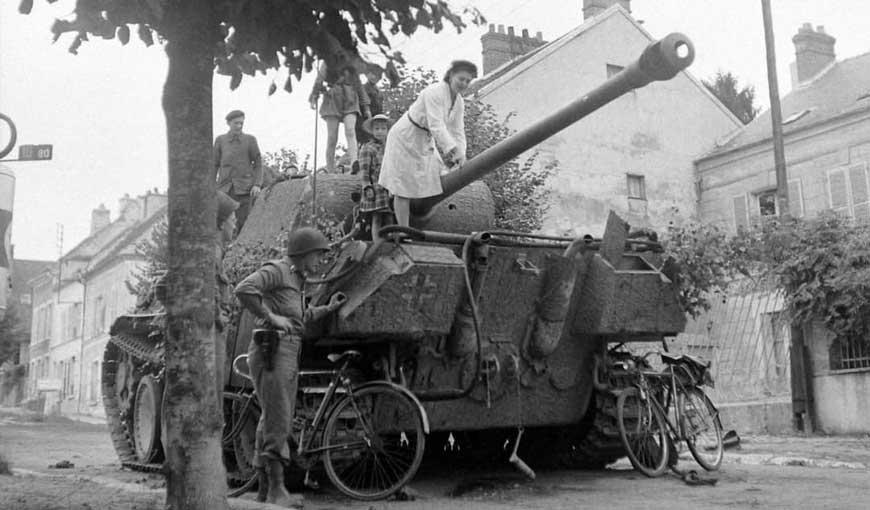 Photo - Char allemand abandonné. Civils et soldats américains à Château-Thierry en septembre 1944 