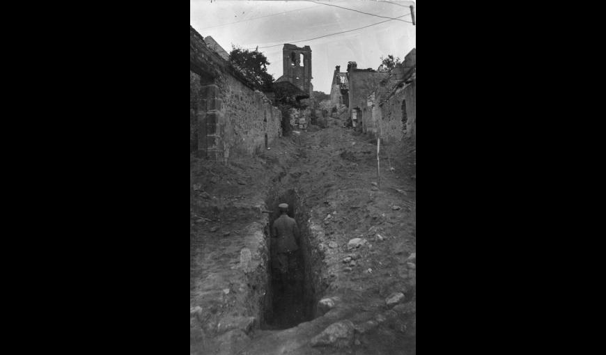 Soldat allemand dans une tranchée au milieu de la rue donnant sur l'église de Chivy (Aisne)