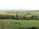 Vue panoramique sur un paysage de collines, champs et bois autour de Craonne, avec des prairies et des arbres au premier plan.